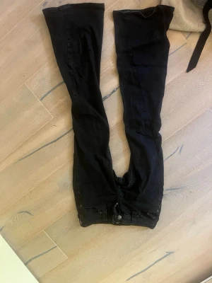 Svarta true religion jeans ”joey” - Säljer ett par svarta bootcut jeans med två stora fickor bak och knappdetaljer. Jeansen har utsvängda ben och klassisk femficksdesign. Perfekta för dig som gillar en retro och avslappnad stil. Strl 24, passar xs/s