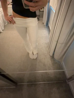 Vita yoga pants - Säljer ett par vita yoga pants. De är tighta upptill och har en mjuk, stretchig passform som sitter snyggt på kroppen. Byxorna har små små fläckar på låret men inget man tänker på eller syns särskilt mycket