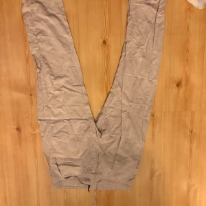 Beige linnebyxor med dragsko - Säljer ett par beige linnebyxor med avslappnad passform och dragsko i midjan. Byxorna har raka ben och sidofickor, perfekta för en chill och stilren look. Materialet är lätt och luftigt linne, vilket gör dem sköna att bära under varma dagar. Nypris. 599kr
