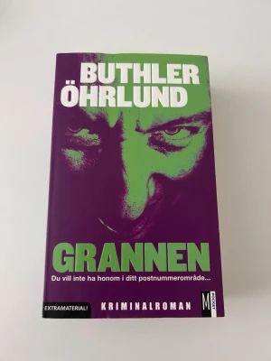 Grannen av Buthler Öhrlund - En spännande kriminalroman med lila och grönt omslag, skriven av Buthler Öhrlund. Boken handlar om Hans Ecker och psykopaten Christopher Silfverbielke. Pocketutgåva med extramaterial, perfekt för dig som gillar nervkittlande deckare.