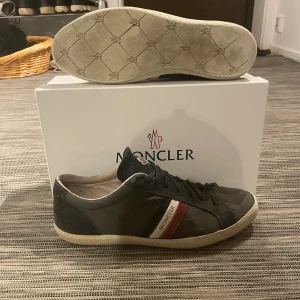 Moncler skor - Säljer ett par riktigt snygga skor från Moncler! Skorna är i mycket bra skick förutom lite slitningar vid hälen samt lite vid kanterna. Låda tillkommer. Om ni har några andra frågor så är de bara att höra av er😊
