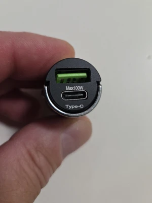 Snabb Billaddare USB-A och USB-C 100W - Smidig billaddare med både USB-A och USB-C (Type-C) port, max 100W. Perfekt för att ladda mobilen, surfplattan eller datorn i bilen. Svart cylinderformad design med metall- och plastdetaljer. Passar i bilens cigguttag.