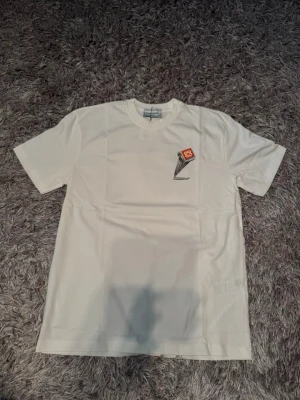 Vit t-shirt från Casablanca - Vit t-shirt från Casablanca med tryck av en pelare och röd logga på bröstet och ryggen. Klassisk rund hals och korta ärmar. Tillverkad i mjuk bomull som känns skön mot huden. Perfekt för dig som gillar stilrena plagg med unik detalj. Tags och påse finns med 