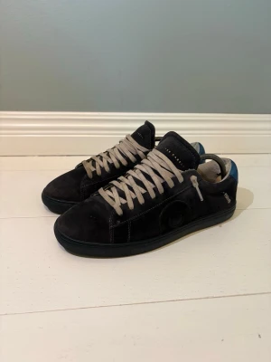 Mörkblå mocka sneakers från Oliver Cabell - Tja! Säljer dessa mörkblå mocka sneakers från Oliver Cabell.                                                           Skorna kostar 2000 nya, plus tullar då de fraktas från USA. Skorna är i bra skick och har endast lite små slitningar, mest vid hälen i skon. Skorna är i storlek 39 men passar 40-41. Själv har jag 42 och de är en aning små därför säljs dem☺️ Skriv gärna vid funderingar!