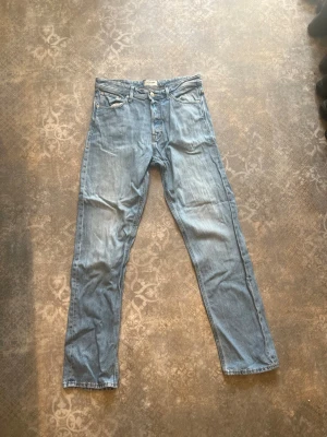 Ljusblå relaxed jeans Jack & Jones - Säljer ett par ljusblå jeans från Jack & Jones, modellen Relaxed Chris. Jeansen har relaxed fit, klassisk femficksdesign och knäppning fram. Tillverkade i mjukt denimtyg som ger en avslappnad och trendig look.