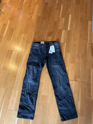 Svarta retrojeans Helt nya från LAB Industries - Säljer ett par svarta jeans från LAB Industries i retro/regular fit. Klassisk femficksmodell med raka ben och knappgylf. Jeansen är tillverkade i slitstark denim och har en stilren look som passar till det mesta. Helt nya strlk 158-164