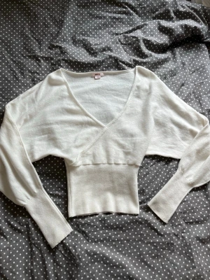 Gina Tricot 14+ fitted wrap sweater  - Säljer denna superfina omlotttröjan från Gina Tricot i 14+ xs🪽 Aldrig använd, köpte och sydde fast lite i omlotten så den inte skulle glida ner, se bild. Men har bara provat den, inte använt💓 Såå fin nu till hösten🥧🍁  Välj helst instabox!