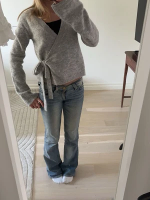 Grå omlottkofta från Gina Tricot - Grå stickad omlottkofta från Gina Tricot.