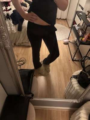 Svarta kostymbyxor - Säljer ett par svarta kostymbyxor med bootcut-modell och låg midja. De är stretchiga och sitter tajt upptill men har utsvängda ben. Perfekta till en avslappnad look och superbekväma att bära hela dagen.