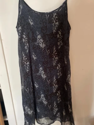 Svart klänning med mönster - Säljer en svart klänning med vackert ämönster. Klänningen har ärmlös design och rund halsringning💙