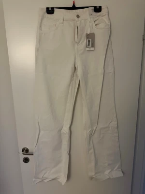 Vita wide leg jeans EUR 38 - Säljer ett par vita wide leg jeans i full längd med hög midja och regular fit. Klassisk femficksmodell med knapp och dragkedja framtill. Perfekta för en clean och trendig look.