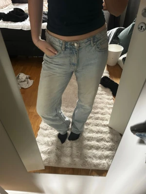Ljusblå raka jeans med hög midja - Säljer ett par ljusblå jeans med rak passform och midwaist. Jeansen har klassisk femficksdesign och är tillverkade i denim med en lätt tvättad look. Perfekta för en avslappnad och trendig stil. Storlek 40/L. Inget slitage, aningens urtvättade.