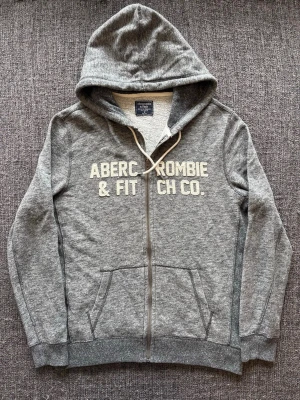 Abercrombie & fitch zip up ~ sällsynt  - Abercrombie & Fitch zip up grå | st M | Snygg zip up i grå färg. Sällsynt och eftertraktad vintage modell som produceras ej längre och går knappt att få tag på. Vintage 2000’s modell. Perfekt nu till våren/sommaren 🏄 Kan även gå ner lite i pris vid snabb affär!