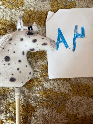 Prickig käpphäst🎀 - Säljer en käpphäst med vit plysch och svarta prickar. Hästen har en kort vit man i garn och svarta detaljer runt ögon och nos.