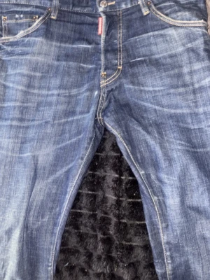 Blå original jeans med raka ben - Säljer ett par blå jeans med snyggt sliten tvätt och raka ben. Jeansen har klassiska fem fickor, kontrastsömmar och knappgylf. Perfekta för en avslappnad och trendig stil.  Lite mindre än 1 år men i jätte bra skick nypris 6400 när dom fanns på care of Carl