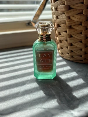 Kayali Maui In A Bottle parfym - Kayali Maui In A Bottle Sweet Banana  är en parfym i en snygg, turkosgrön, sexkantig glasflaska med guldig och transparent kristallformad kork. Flaskan har en modern och lyxig känsla, perfekt för dig som gillar unika dofter.10ml, se hur mycket som är kvar