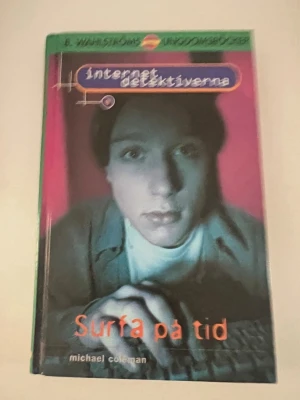 Surfa på tid - Internetdetektiverna - Ungdomsbok från B. Wahlströms serie Internetdetektiverna, skriven av Michael Coleman. Omslaget är färgstarkt med en person vid dator och titeln i orange text. Boken har hårda pärmar och handlar om mysterier på nätet.