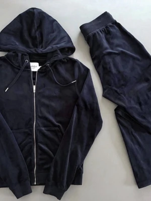 Mörkblått velour loungewear-set - Supermjukt loungewear-set i mörkblå velour från Bread & Boxers. Setet består av en hoodie med dragkedja, fickor och dragsko samt matchande byxor med resår och dragsko i midjan. Perfekt för chill dagar och hemmamys.