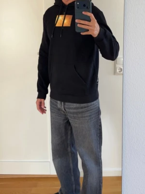 Hoodie - Svart hoodie med tryck fram och bak. Storlek XS. 