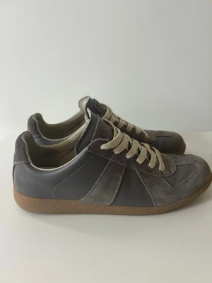 Maison Margiela Gats Skor - Snygga sneakers i grå från margiela, skorna var köpa här på plick för 2 år sen. De har använts fåtal gånger och är i bra skick. Inga synliga defekter förutom lite smuts och creases, innersulan har bytts ut av föra ägare mot en liknande sula antar jag?OBS: BOX INGÅR!!! Kontakta gärna vid intresse🙌