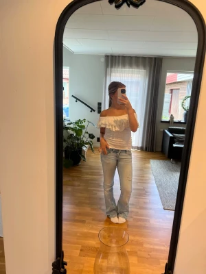 Vit offshoulder topp med volang - Supersöt vit offshoulder topp med bred volang och skönt material. Toppen är croppad och ärmlös. 