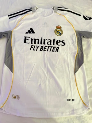 Real Madrid vit matchtröja Adidas - Snygg vit Real Madrid matchtröja från Adidas med svarta och gula detaljer. Har aldrig använt den för att den va lite för stor.