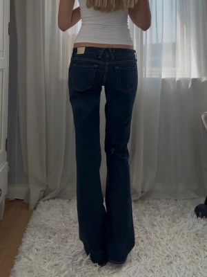 Mörkblå bootcut jeans med låg midja - Sååå snygga lågmidjade vintage bootcutjeans. Storlek 29.  Midjemått: 42cm Innerbenslängd: 87cm  #mörkblåJeans #darkwashjeans #bootcut #bootcutjeans #flarejeans #highwaist #högmidjade #tall #longlength #autumnstyle #höstmode #fallfashion #oldmoney #quietluxury #vintage #90sfashion #y2k #timeless #capsulewardrobe #cleanGirl #preppy #denim #klassisk #trendig #vardagsstil #chic #pinterest #aesthetic