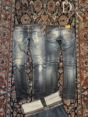 Vintage dry Japan nudie Selvedge jeans - Helt otroliga nudie jeans med en tvätt som kan tyckas är för bra för att vara sant, dem har förvarats bra och står i 10/10 skick, modellen är Lean Dean då de ej passar mig idealt så visar jag en bild på hur samma modell(inte samma jeans) passform är. Midja:41,5cm Längd:107cm benöppning:17cm