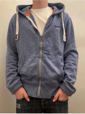 Superdry zip hoddie - Säljer en super det zip hoodie i storlek M. Den är i mycket bra sick och har inga defekter. Det är bara att höra av sig vid fler frågor🙌