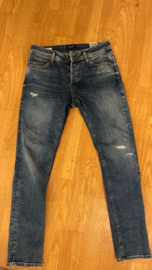 Jack and Jones jeans med slitningar - Ettt par super fetta Jack and Jones jeans i storlek 30:30😄 har använts sparsamt och har inga defeekter samt missfärgningar. Hör av vid minsta frågan och priset kan diskuteras vid en snabb affär.