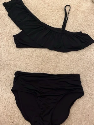 Svart bikini med volang och asymmetrisk axel - Snygg svart volangbikini 