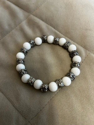 (Chrome hearts) Vitt pärlarmband - Snyggt chrome hearts armband med vita runda pärlor och dekorativa silverfärgade mellanpärlor. Elastiskt band som gör det enkelt att ta på och av.  Priset kan diskuteras, dm för frågor!