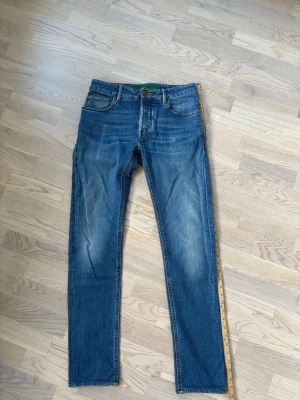 Jättefina handpicked jeans w30 - Kap! Superfina populära och eftertraktade Handpicked jeans i w30 säljes. 106 cm total längd och 40 cm breda i midjan. Riktigt snygg badge och otroliga jeans! Inga hål eller fläckar i utmärkt skick och tveka inte vid minsta fråga eller fundering!