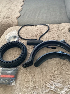 Tillbehörspaket till elscooter - Säljer ett kit med svarta tillbehör till elscooter, inklusive punkteringsfritt däck, stänkskärmar, handtag, reflexer och lås. Perfekt för dig som vill uppgradera eller byta ut delar på din elsparkcykel.