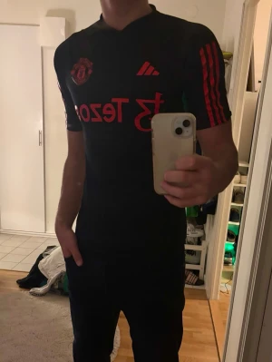 Manchester United svart tränings t-shirt - Säljer en svart Manchester United tränings t-shirt från Adidas