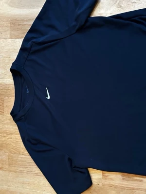 Svart Nike t-shirt med kort ärm - Snygg svart t-shirt från Nike med klassisk vit logga på bröstet. T-shirten har korta ärmar och är tillverkad i ett mjukt och lätt material som passar perfekt till träning eller chill. Enkel och stilren design som funkar till det mesta. Hör av er vid funderingar 😁
