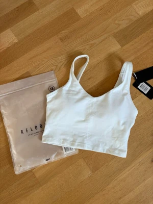 Core V-top Relode  - Säljer en vit top med inbyggd sport bh från Relode i modellen ”Core V-top” i strl xs. Aldrig använd, med prislapp kvar. Tyvärr för liten för mig därför säljs den💕  Nypris: 449kr
