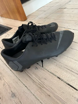 Nike Mercurial svarta fotbollsskor konstgräs  - Säljer ett par svarta Nike Mercurial fotbollsskor med snörning för konstgräs. Säljer på grund av att jag köpt andra ATG skor