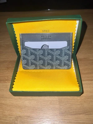grå korthållare i läder - Snygg grå korthållare klassiskt mönstrat läder. Perfekt för att hålla koll på dina kort med stil. Kommer i original grön ask med gul insida. Smidig och tunn design som passar i fickan aldrig använd pris kan diskuteras 