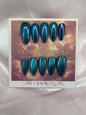 Narissa (M);Meidum Almond - Handgjorda press-on nails i Medium Almond med djup teal cat eye-effekt. Det magnetiska skimret skiftar mellan mörkblått och turkost beroende på ljus och vinkel.  10 handgjorda naglar i storlek M Prep-kit medföljer. 