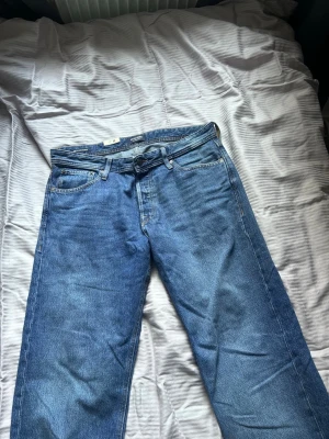 Blå relaxed jeans från Jack & Jones - Säljer ett par blå jeans från Jack & Jones i modellen Relaxed/Chris. Jeansen har en avslappnad passform, klassisk femficksdesign och är gjorda i denim. Perfekta för en chill och stilren look.