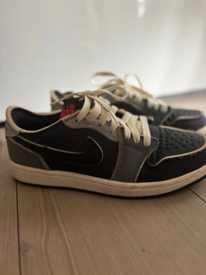 Nike Air Jordan 1 Low svart/grå - Snygga Nike Air Jordan 1 Low sneakers i svart och grått.