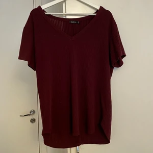 Ribbad t-shirt - En ribbad t-shirt från boohoo i färgen ”berry”. Har funnits snörning fram men det är avklippt, därav priset. Köptes för 130kr. Storlek 44.
