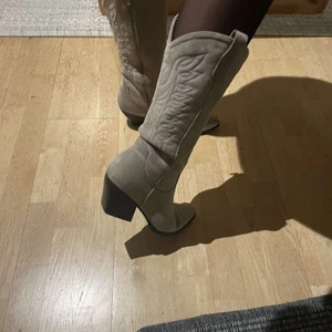 Cowboy boots  - Sjukt snygga cowboyboots i beige mocka. Väldigt fina detaljer. Lagom långa också passar lika bra på bara ben. Dessa är i strlk 40, skulle säga att de passar mindre fötter också (39). Inköpta (nya) nu i somras och endast använda 2-3 gånger. Skriv till mig på dm för frågor och även för budgivning 💖