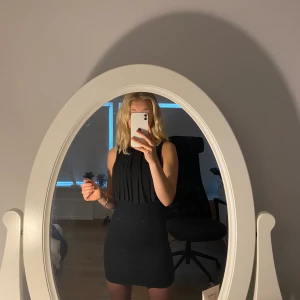 Festklänning  - Snygg svart festklänning med volanger. Ryggen är något öppen. Fint skick då den nästan inte är använd. Säljer eftersom den inte kommer till användning. Storlek xss men skulle säga att den passar xxs-s då den är väldigt stretchig!