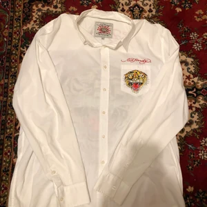 Ed hardy skjorta - Nej men tjena! Jag säljer denna galet coola ed hardy skjorta med den klassiska tiger snubben på baksidan och framfickan därbak i rightstones, sjukt najs till sommaren då den är väldigt luftig och ba almänt najs o glida runt i på sommaren