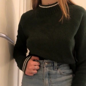 Grön stickad tröja i strl XS - Superskön grön stickad tröja med vita detaljer i ärmen o kragen. Köparen står för frakt. 