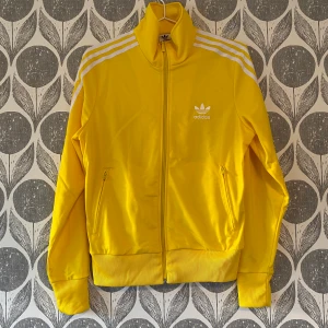 Adidas originals tracksuit zipper  - Adidas originals tröja i gult. Oanvänd. Säljer även brallorna till i annan annons. 