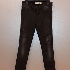 Svarta lågmidjade LISA jeans i stl 36  - Säljer dessa mörgråa/svarta "LISA" jeans från Ginatricot. De är endast provade ett fåtal gånger men säljes då de är för låga för mig som är 155 cm. Jeansen har fina slitningar och är i stl 36.