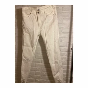 Vita jeans - Vita jeans med  low waist och slitningar vid fötterna 